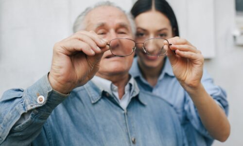 old-man-standing-gray-backround-with-his-granddaughter (1)